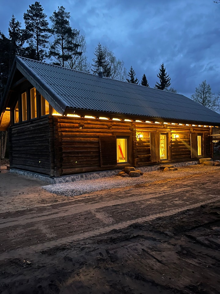 Guļbūves māja vakarā ar apgaismojumu