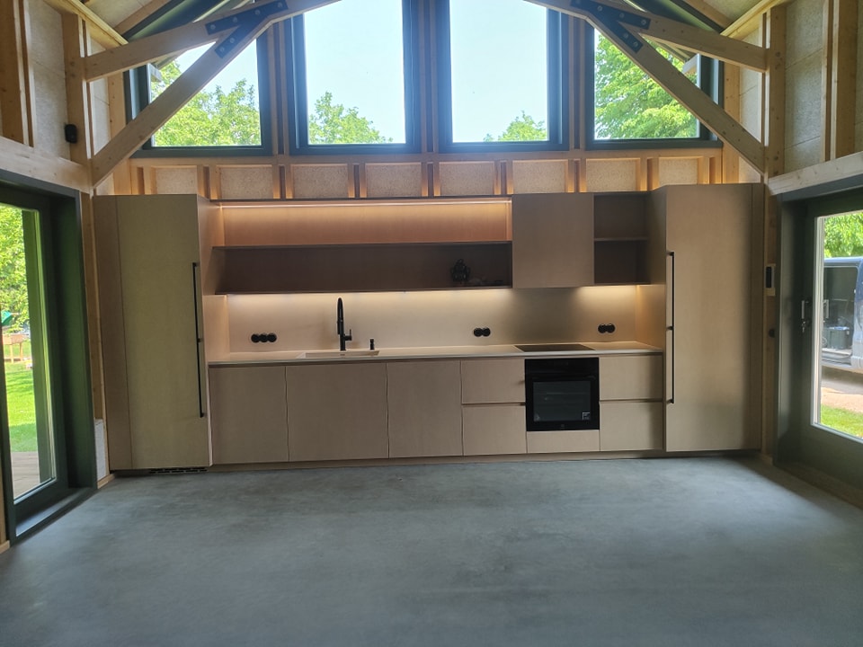 Koka mājas virtuves zona ar individuālu dizainu un apgaismojumu